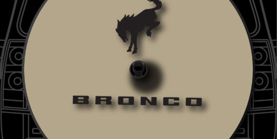 Bronco silhouette tan badge on custom tire cover for Bronco vehicles.